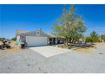 Charming single-story home with a two-car garage and desert landscaping on a sunny day at 2251 Bridger St, Pahrump, NV 89048