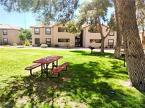 Apartment building with picnic tables in a grassy communal area, creating an inviting outdoor space at 2451 N Rainbow Blvd # 2073, Las Vegas, NV 89108