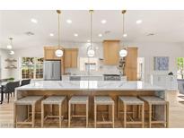 Bright, updated kitchen with island seating, modern appliances, and stylish pendant lighting at 5157 Future Dr, Las Vegas, NV 89130