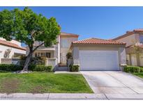 Charming two-story home with red tile roof, manicured lawn, mature tree and gated courtyard at 8196 Horseshoe Bend Ln, Las Vegas, NV 89113