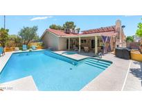 Sparkling in-ground pool and spa with a covered patio perfect for relaxing and entertaining at 8700 Isola Dr, Las Vegas, NV 89117
