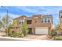 Two-story home with tan exterior, stone accents, manicured landscaping, and a two-car garage at 9655 Skye Star Ave, Las Vegas, NV 89166