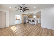 Open-concept living room features modern ceiling fan, wood floors, and adjoins kitchen for seamless entertaining at 1209 S 17Th St, Las Vegas, NV 89104