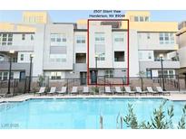 Modern condo building with pool and lounge chairs for residents in Henderson, Nevada at 2507 Silent View Ave, Henderson, NV 89044