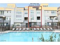 Modern townhome with community pool and lounge chairs, perfect for relaxing and enjoying the outdoors at 2507 Silent View Ave, Henderson, NV 89044