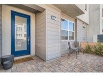 Inviting front entrance featuring a bright blue door and charming outdoor seating area at 2507 Silent View Ave, Henderson, NV 89044
