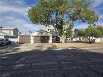 Charming two-story home featuring a three-car garage, mature tree, and low-maintenance landscaping at 3056 Garnet Ct, Las Vegas, NV 89121