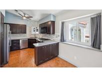 Well lit kitchen featuring stainless steel appliances, dark cabinetry, and a window looking out to an exterior view at 371 Legacy Dr, Henderson, NV 89014