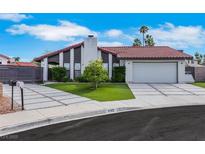 Charming single-story home featuring a red tile roof, modern driveway, and lush landscaping at 4143 Chela Cir, Las Vegas, NV 89120