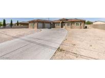 Spacious desert home featuring a long driveway and three-car garage, perfect for car enthusiasts at 6131 Rio Vista St, Las Vegas, NV 89130