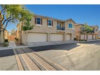 Charming townhome showcases a three car garage and neutral stucco exterior under a bright blue sky at 6255 W Arby Ave # 258, Las Vegas, NV 89118