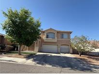 Two-story home featuring a spacious two-car garage, manicured lawn, and mature trees at 6351 Davidson Ct, Las Vegas, NV 89110