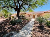 Charming single-story home featuring desert landscaping, a tile roof and a wrought iron gate at 7661 Angel Crest Cir, Las Vegas, NV 89117