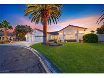 Charming single-story home featuring a well-manicured lawn, mature palm trees, and a three-car garage at 7670 Descanso Ln, Las Vegas, NV 89123