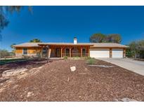 Charming single-story home with a covered porch, well-maintained landscaping, and a two-car garage at 7950 Red Barn Dr, Las Vegas, NV 89123