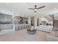 Open-concept living room showcases seamless flow to the kitchen, complemented by modern furnishings and stylish decor at 7983 Texas Hills St, Las Vegas, NV 89113