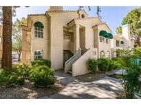 Condo building exterior with tan stucco, green awnings, and desert landscaping at 2251 Wigwam Pkwy # 824, Henderson, NV 89074