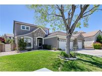 Charming home features a well-manicured lawn, mature tree, and attractive stone accents at 2285 Moresca Ave, Henderson, NV 89052