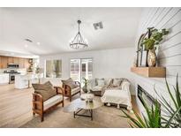 Bright living room with modern chandelier, fireplace, and views to the backyard at 3009 Anna Bay Dr, Las Vegas, NV 89134
