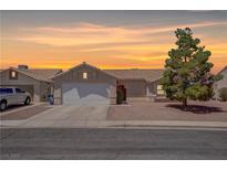 Charming single-story home with a well-maintained front yard and a two-car garage at sunset at 394 Lombardy Cir, Henderson, NV 89015