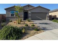 Charming single-story home with xeriscaped front yard and paver driveway, presenting modern curb appeal at 411 Hellebores Ave, North Las Vegas, NV 89084