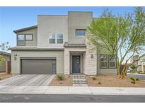 A modern two-story home with a gray exterior, complemented by a stone entrance and well-maintained landscaping at 6830 Fallen Rock St, North Las Vegas, NV 89084