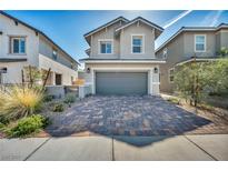 Two-story home features a charming front yard with a two car garage and a beautiful brick driveway at 688 Monroe Hill Pl, Henderson, NV 89011