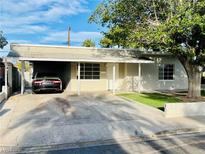 Single-story home featuring a covered carport and a well-maintained lawn at 700 N Minnesota St, Las Vegas, NV 89107