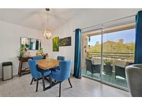 Dining area features a modern light fixture, balcony access, and seating for four at 701 Wheat Ridge Ln # 203, Las Vegas, NV 89145