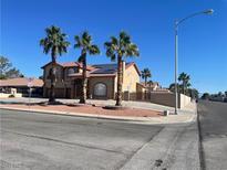 Two-story home with desert landscaping and palm trees adding to curb appeal at 7020 King Solomons Ct, Las Vegas, NV 89117
