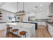 Bright, modern kitchen with large marble island, stainless appliances, and custom white cabinetry at 7289 Sea Anchor Ct, Las Vegas, NV 89131