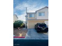 Two story home featuring drought resistant front yard, two-car garage, and covered entryway at 779 Peregrine Falcon St, Henderson, NV 89015