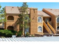 Charming condo showcasing classic architecture, stairs to the units, and well-maintained landscaping at 7950 W Flamingo Rd # 1077, Las Vegas, NV 89147