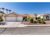 Charming single-story home featuring a terra cotta roof, two-car garage, and manicured landscaping at 8105 Tropic Isle Cir, Las Vegas, NV 89128