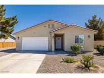 Charming single-story home with stucco exterior, two-car garage and desert landscaping at 100 Eton St, Pahrump, NV 89048