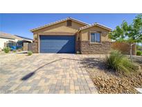 Charming single-story home featuring a stone facade, well-manicured landscaping, and a two-car garage at 2099 Port Royal Dr, Laughlin, NV 89029