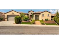 Charming single-story home featuring desert landscaping, a brick walkway, and an attached two-car garage at 2373 Ozark Plateau Dr, Henderson, NV 89044