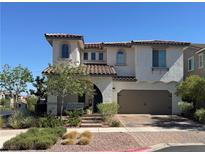 Charming two-story home featuring a tile roof, arched entry, and a well-manicured front yard at 242 Homeward Way, Henderson, NV 89011