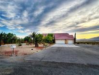 Charming single-story home featuring a two-car garage and a well-manicured front yard with mature palm trees at 2780 Avenue Of The Stars, Pahrump, NV 89060