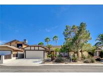 Charming single-story home with a well-manicured lawn, mature trees, and attached two-car garage at 6521 Faith Peak Dr, Las Vegas, NV 89108