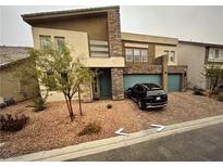 Contemporary two-story home with a stone facade, two-car garage, and xeriscaped front yard at 8738 Stella Nova St, Las Vegas, NV 89139