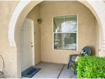Inviting front porch with archway, comfortable chair, and well-maintained landscaping offers a warm welcome at 10001 Peace Way # 1250, Las Vegas, NV 89147