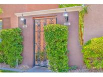 Inviting courtyard entrance with secure gate and well-manicured hedges for added privacy at 10667 Olympic Pine Dr, Las Vegas, NV 89135