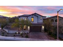 Charming two-story home with a tile roof and a well-manicured front yard against a colorful sunset backdrop at 11856 Barona Mesa Ave, Las Vegas, NV 89138