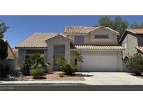 Charming two-story home featuring a tile roof, desert landscaping, and an attached two car garage at 1745 Walingwood Dr, North Las Vegas, NV 89031