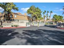 Gated community entrance featuring the Meadows sign surrounded by lush landscaping at 230 Mission Newport Ln # 104, Las Vegas, NV 89107