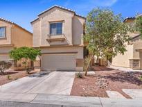Two-story home featuring a two-car garage, desert landscaping, and a neutral color stucco exterior at 3040 Balcones Fault Ave, North Las Vegas, NV 89081