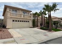 Two-story stucco home with a two-car garage, balcony, and desert landscaping at 3340 Shallow Pond Dr, Las Vegas, NV 89117