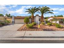 Charming single-story home featuring a two-car garage, mature palm trees, and desert landscaping at 4016 Stormcrest Dr, Las Vegas, NV 89107