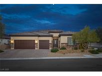 Charming single story home with a desert landscape, two car garage, and stone accents at dusk at 5234 Savannah Rose St, Las Vegas, NV 89149